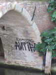 833732 Afbeelding van graffiti met de tekst 'DOMSTAD ANTIFA' onder de Weesbrug aan de oostzijde van de Oudegracht te Utrecht.
